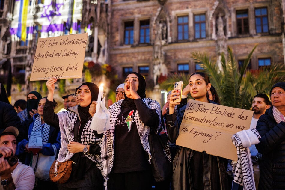 Mehrere Frauen zeigten während einer Kundgebung für Palästina auf dem Marienplatz diverse Schilder.