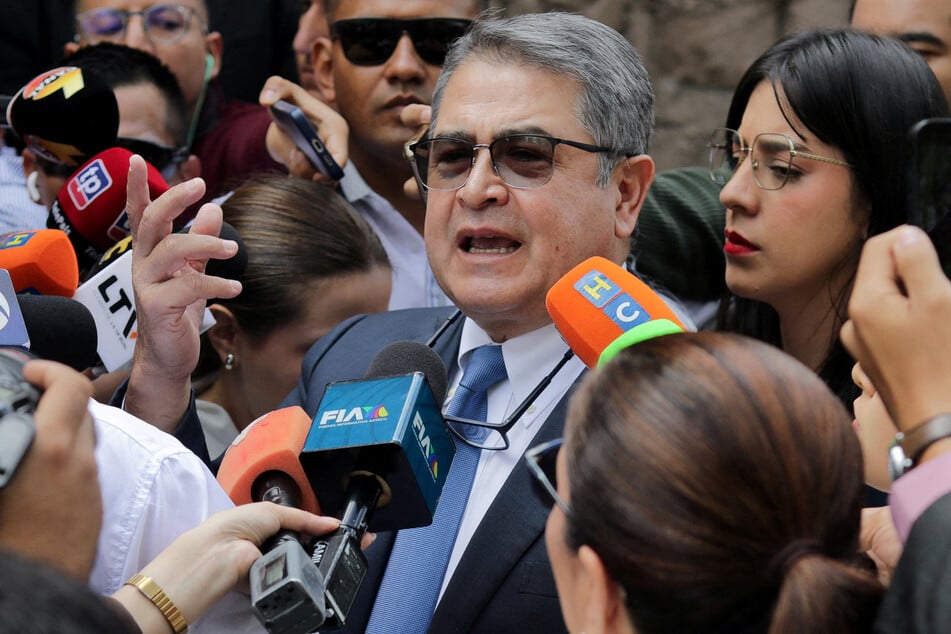 Members of the media surround former Honduran President Juan Orlando Hernandez as he arrives at the Supreme Court in Tegucigalpa on August 3, 2026.