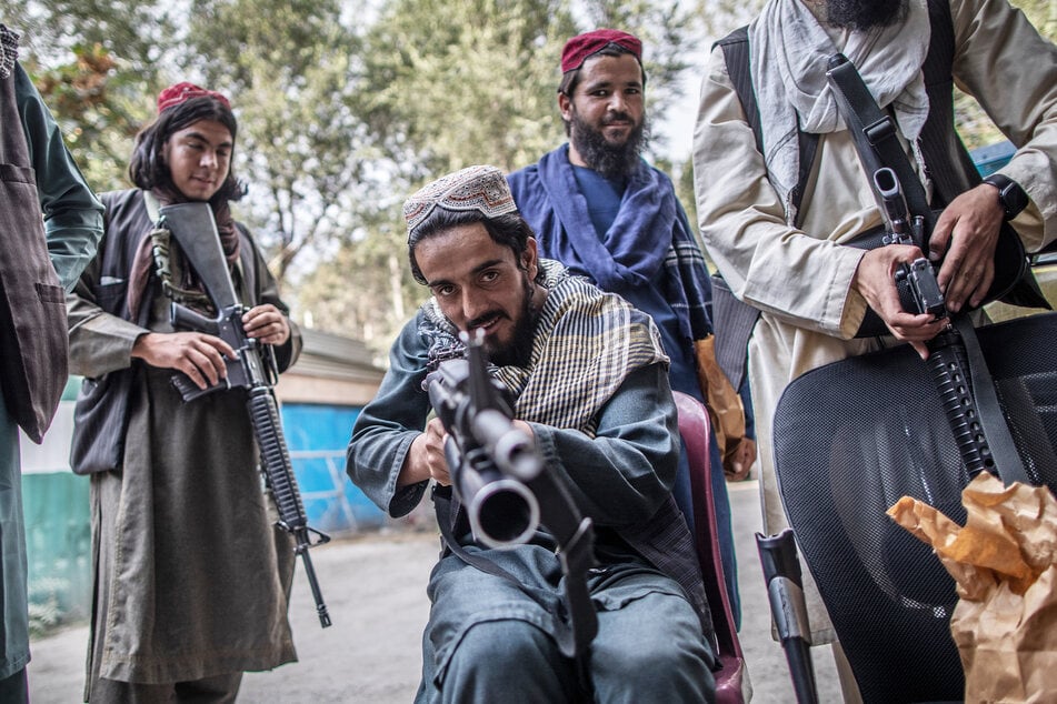 Ein junger Taliban-Kämpfer zielt zum Spaß mit seinem Gewehr in Richtung Fotograf.