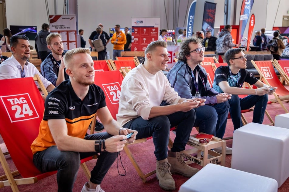 Ein Highlight auf der Messe: Besucher können mit Jonas Greif (l.) und Streamer Smexy (2.v.l) auf der großen Leinwand Mario Kart spielen.