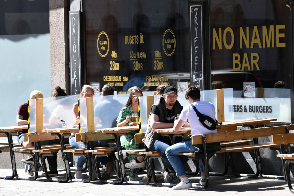 Schweden, Stockholm: Trennwände wurden zwischen den Tischen eines Restaurants zum Schutz der Kunden angebracht.