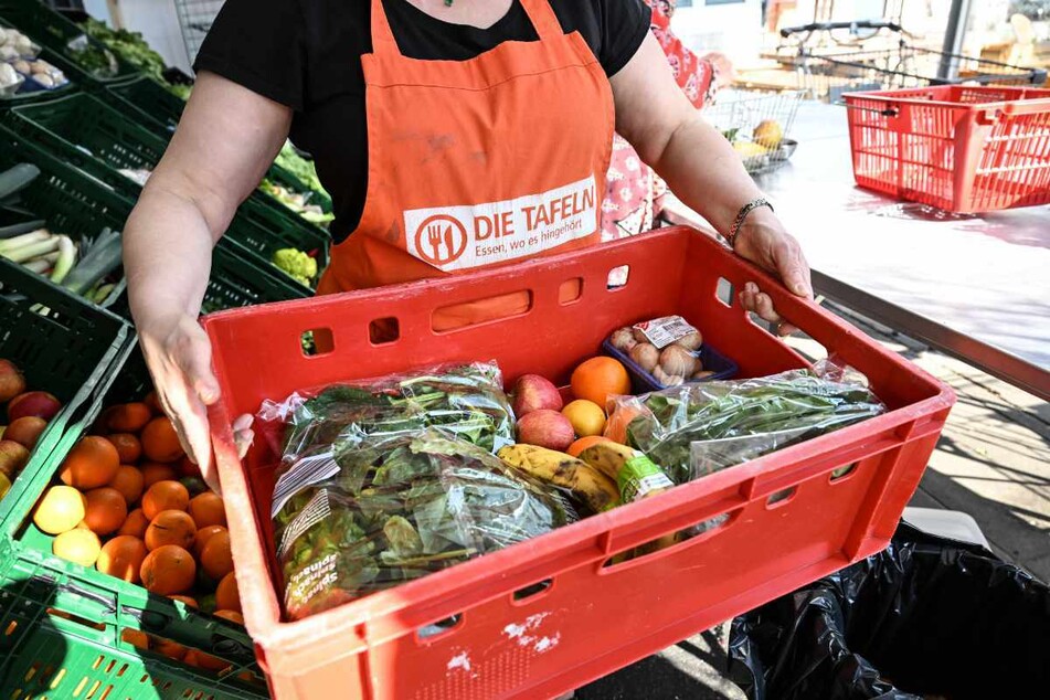 Singen Am Hohentwiel (Kreis Konstanz): Eine Mitarbeiterin des Tafel-Ladens trägt eine Kiste voll mit Obst und Gemüse.