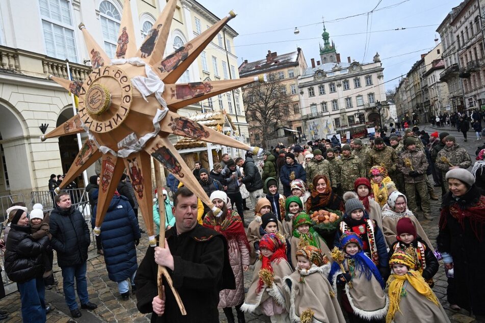 People walk through the streets as they take part in Christmas Eve celebration in Lviv, Ukraine, on December 24, 2023.