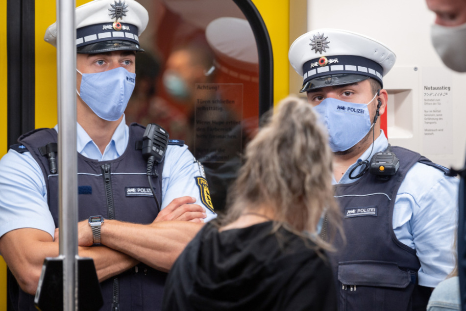 Polizeibeamte kontrollieren in einer Stuttgarter U-Bahn die Einhaltung der Maskenpflicht.