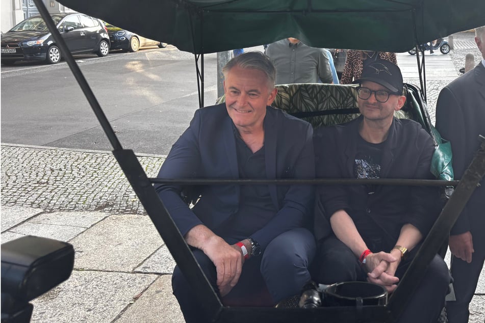 Milan Peschel (57, d.) viajaba en un rickshaw con un compañero de reparto delante.