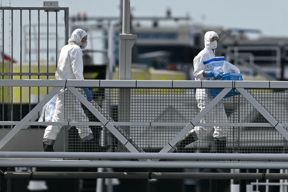 People in protective hazmat suits leave after inspecting the Dutch hantavirus-hit cruise ship MV Hondius as it arrived at the port of Rotterdam on May 18, 2026.