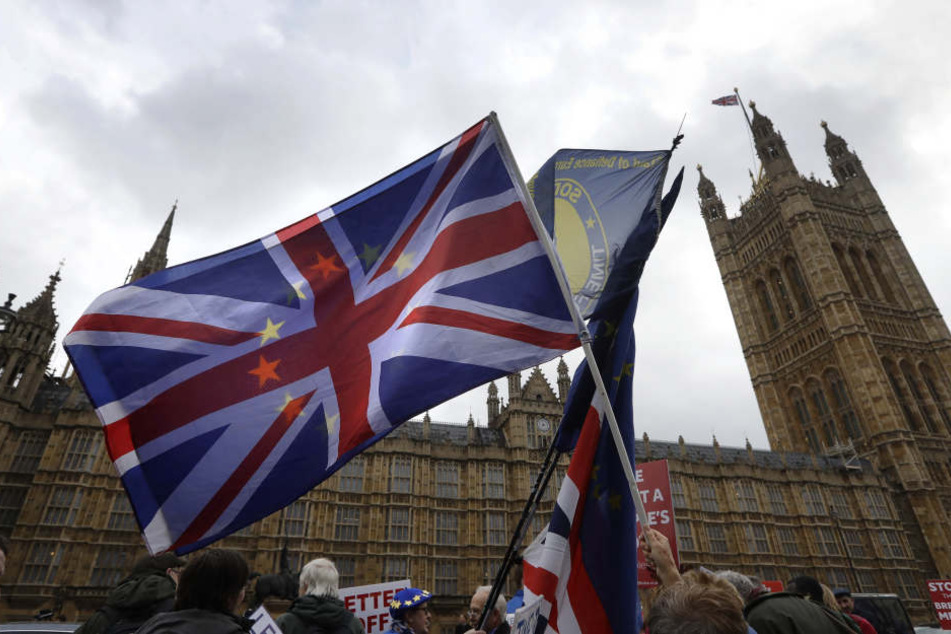 Demonstranten schwenken vor dem Parlament eine britische Fahne.