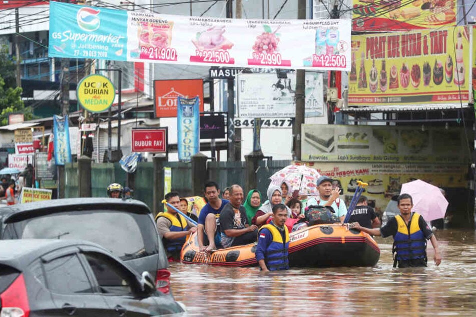 Rettungskräfte evakuieren mit Schlauchbooten Einwohner aus ihren überfluteten Häusern in Jatibening am Stadtrand von Jakarta.