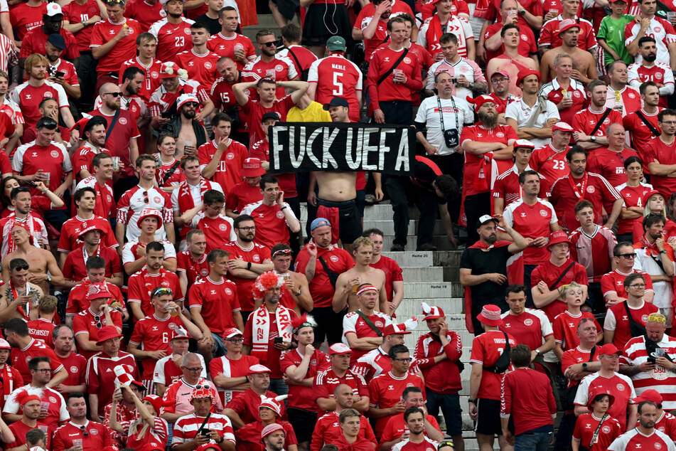 Dänische Fußballfans halten beim EM-Gruppenspiel gegen England ein Banner mit der Aufschrift "F*** UEFA".
