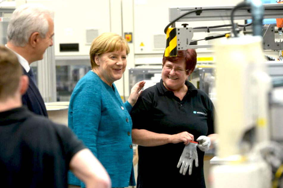 Kanzlerin Angela Merkel (62, CDU) spricht beim Rundgang mit Arbeiterin Bettina Wallicke (li.).