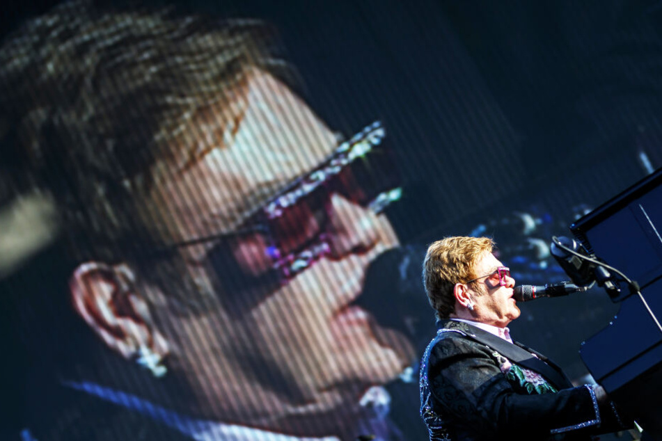 Der britische Sänger Sir Elton John sitzt am Flügel auf einer Bühne (Archivbild).