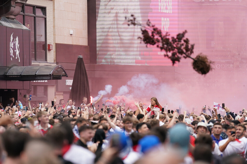 Feiernde England-Fans werfen einen Baum auf dem Leicester Square im Zentrum Londons.