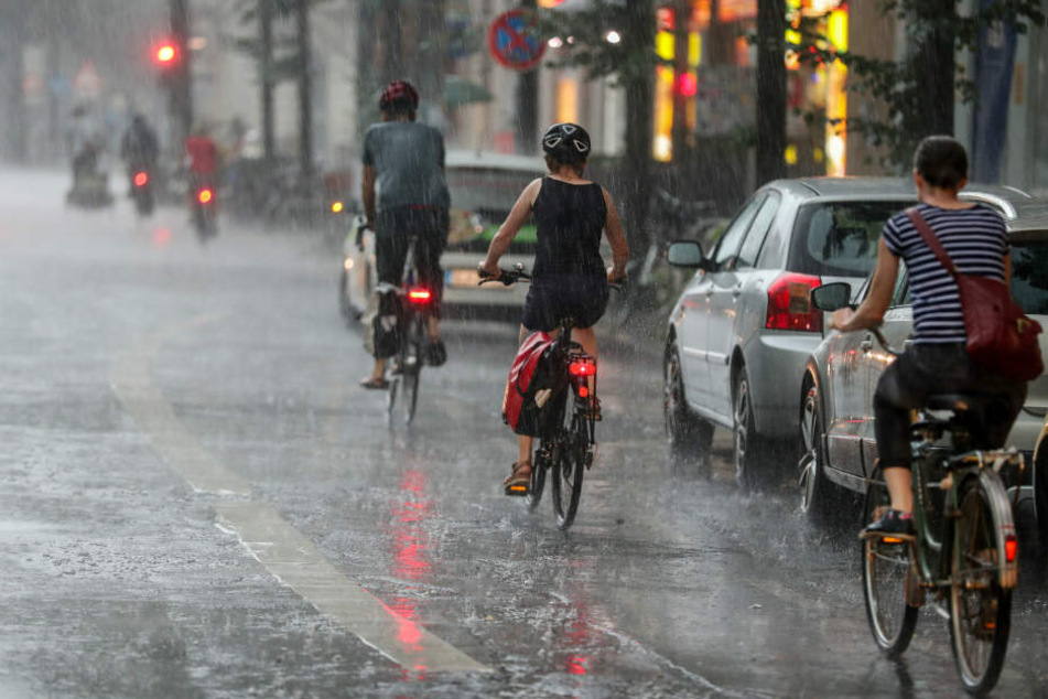 Fahrradfahrer nach einem Unwetter auf den Straßen von Leipzig.