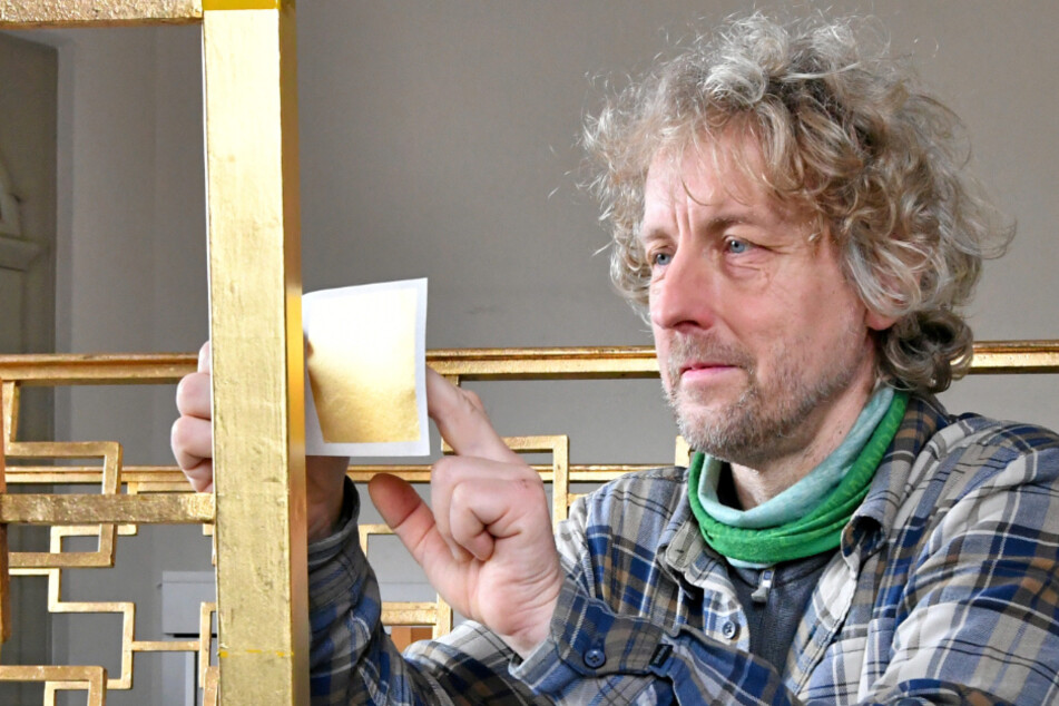 Stadtrat und Handwerker Torsten Schulze (51) trägt in der Cottaer Heilandskirche Blattgold auf einen vorher vorbereiteten Untergrund auf.