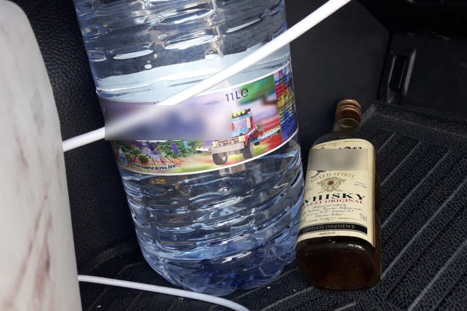 Eine Flasche Wasser und eine Whiskey in einem Lkw.
