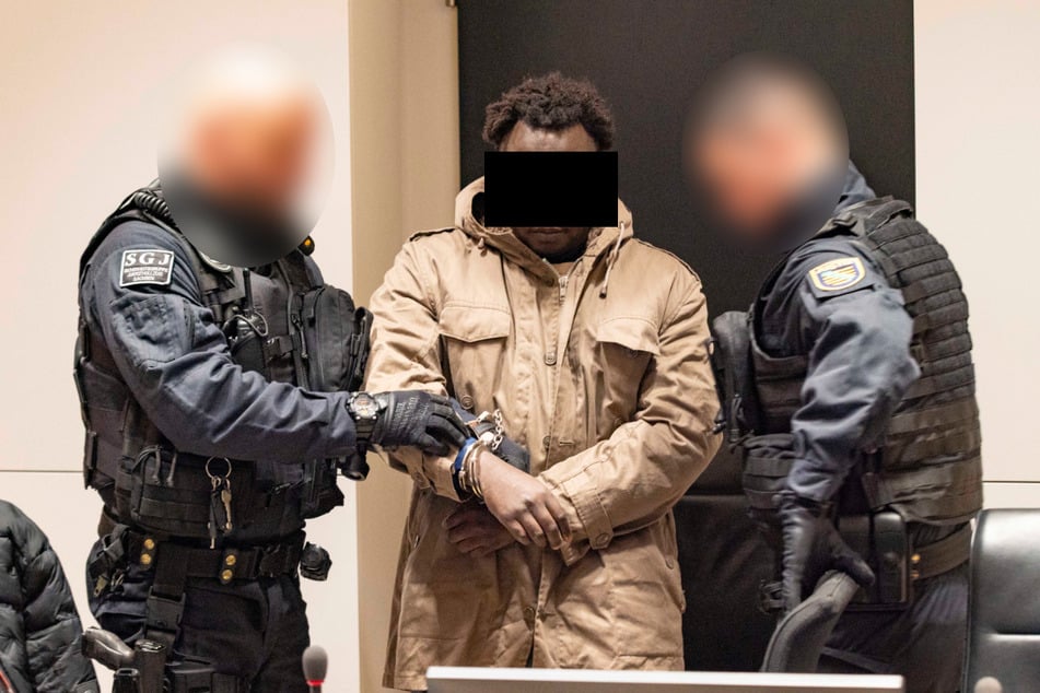 Sani A. (31) wurde von vier Spezialkräften der Justiz und in Hand- und Fußfesseln in den Saal gebracht.