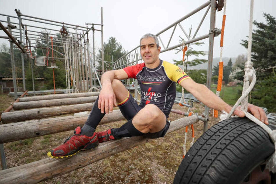 Jörg Eißmann sitzt auf seinem selbstgebauten Parcours für das Training im Extremhindernislauf.