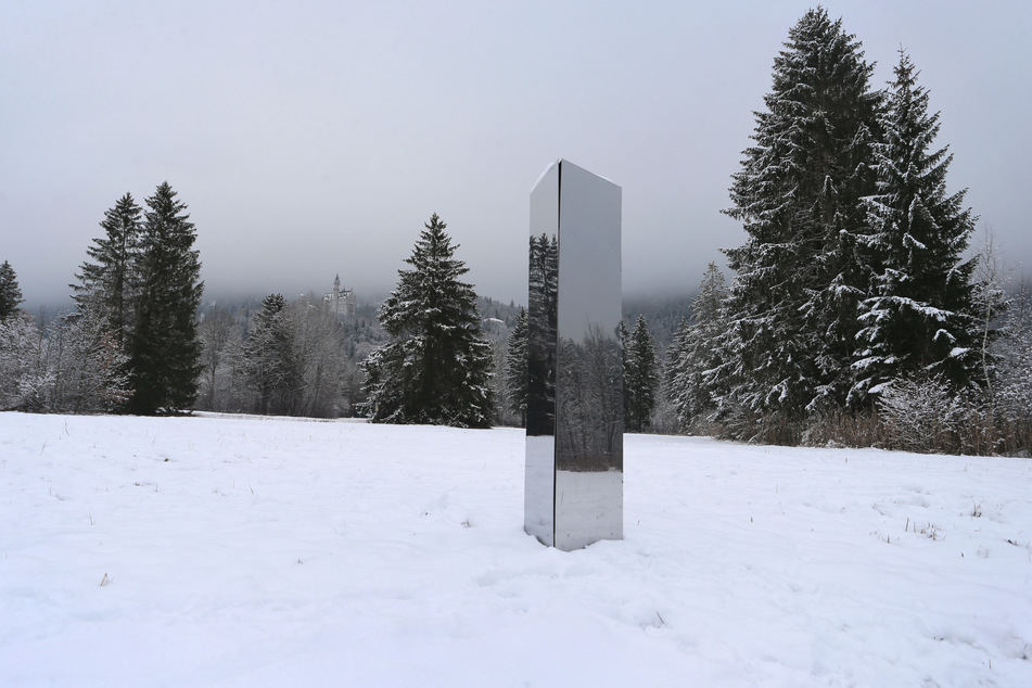 Ein Monolith aus Metall steht unterhalb des Schlosses Neuschwanstein auf einer Wiese im Schnee. Sind auch hierfür die australischen Comedians verantwortlich?