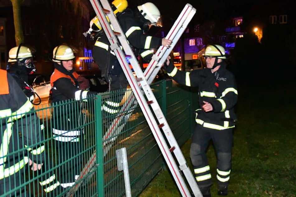 Die Feuerwehrleute mussten über einen Zaun klettern, um das Feuer zu erreichen.