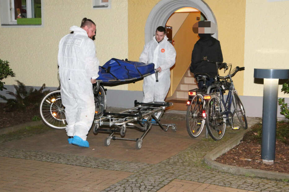 Zwei Mitarbeiter der Gerichtsmedizin tragen die Leiche der 59-Jährige aus dem Haus.