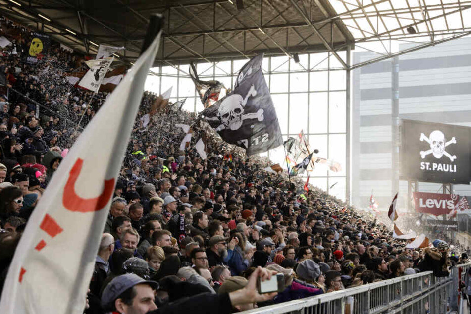 Fans verfolgen ein Spiel des FC St. Pauli im Millerntor-Stadion. (Archivbild)