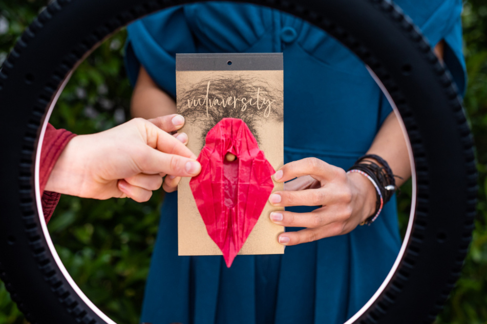 Ein Mitglied des Freiburger Kollektivs "Vulvaversity" hält ein Origami-Modell einer Vulva.