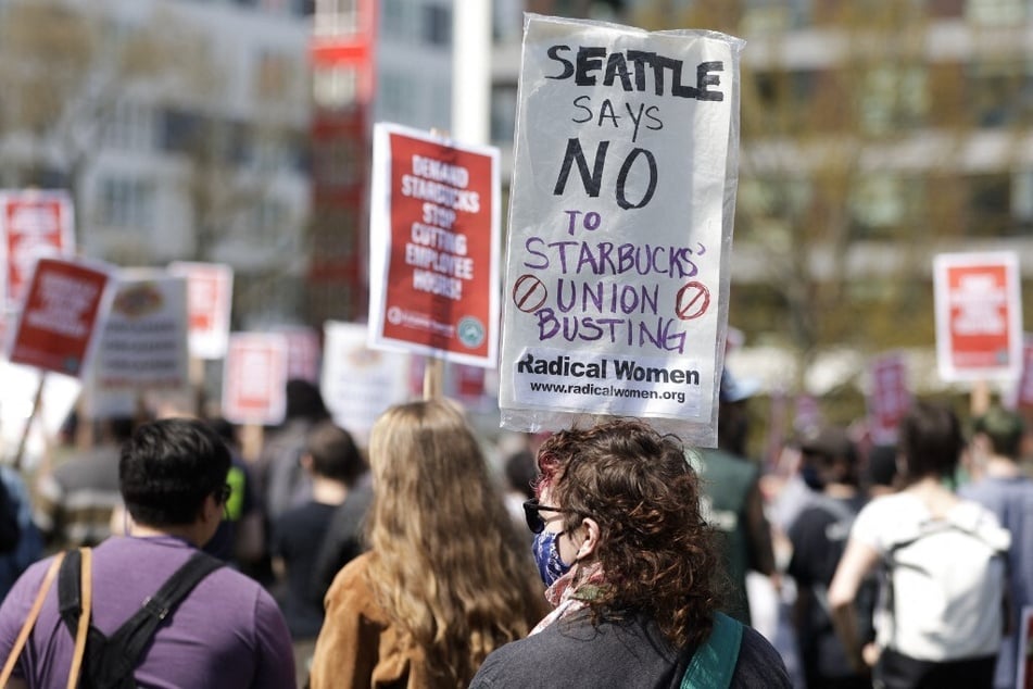 A protester holds a sign reading "Seattle says no to Starbucks' union busting" at a rally in the company's home city.