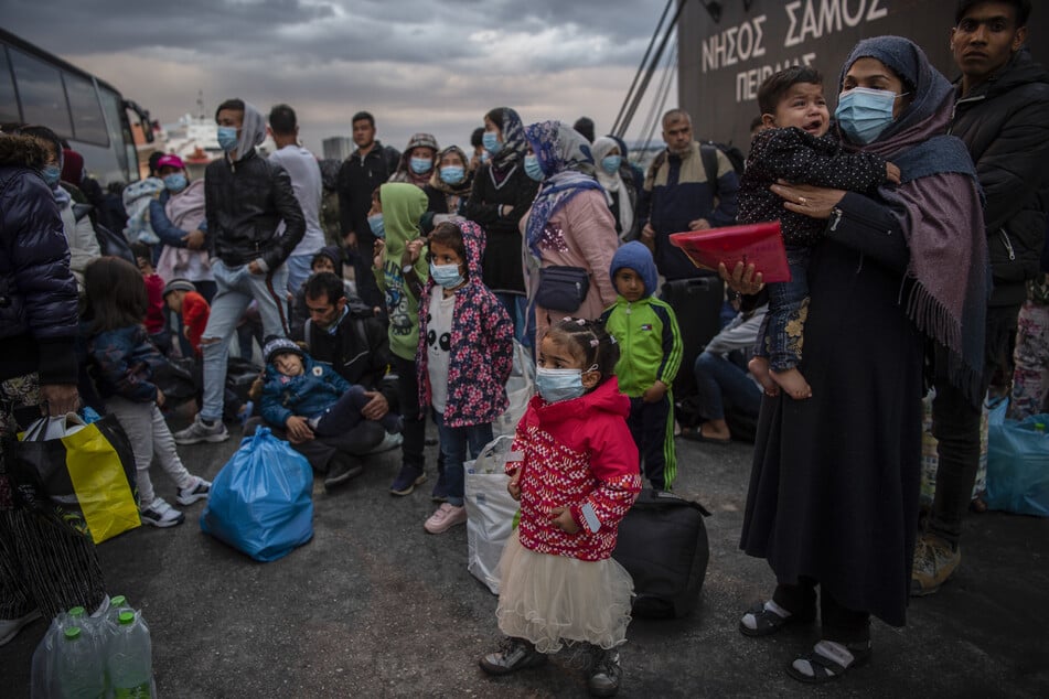 Migranten aus dem Lager Moria, die mit einem Schiff von der Insel Lesbos gekommen sind, gehen im Hafen von Piräus bei Athen an Land.