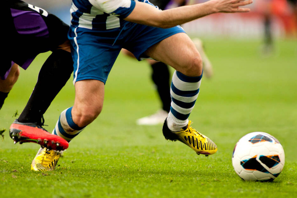 Zwei Fußballspieler kämpfen um den Ball. (Symbolbild)