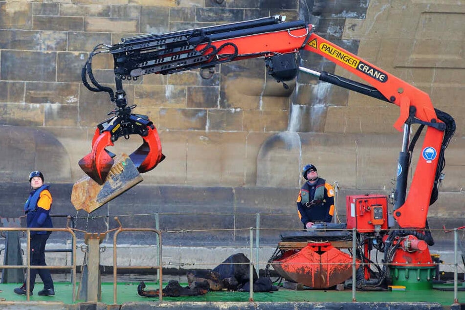 Mit dem Greifer zogen Mitarbeiter des Wasserstraßen- und Schifffahrtsamts gestern einen Sandsteinbrocken aus der Elbe.