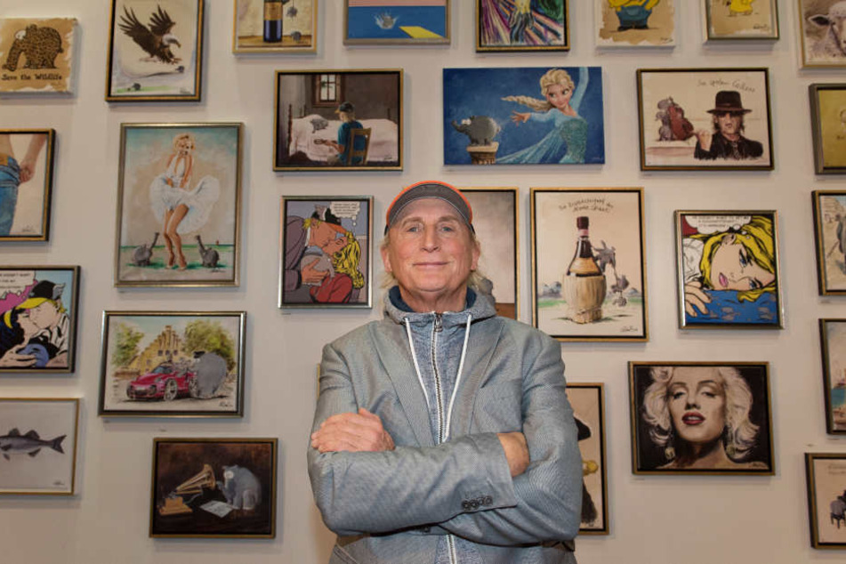 Otto Waalkes steht in einer Ausstellung vor seinen Gemälden.