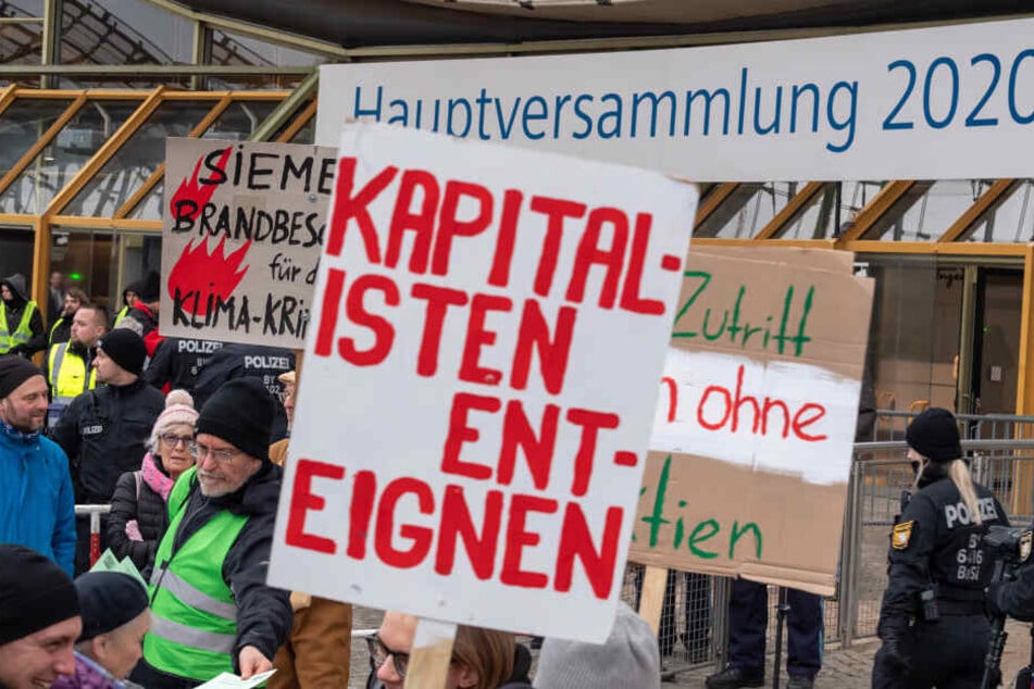 Klimaaktivisten demonstrieren mit Plakaten am Haupteingang zu Beginn der Siemens-Hauptversammlung 2020 vor der Olympiahalle.