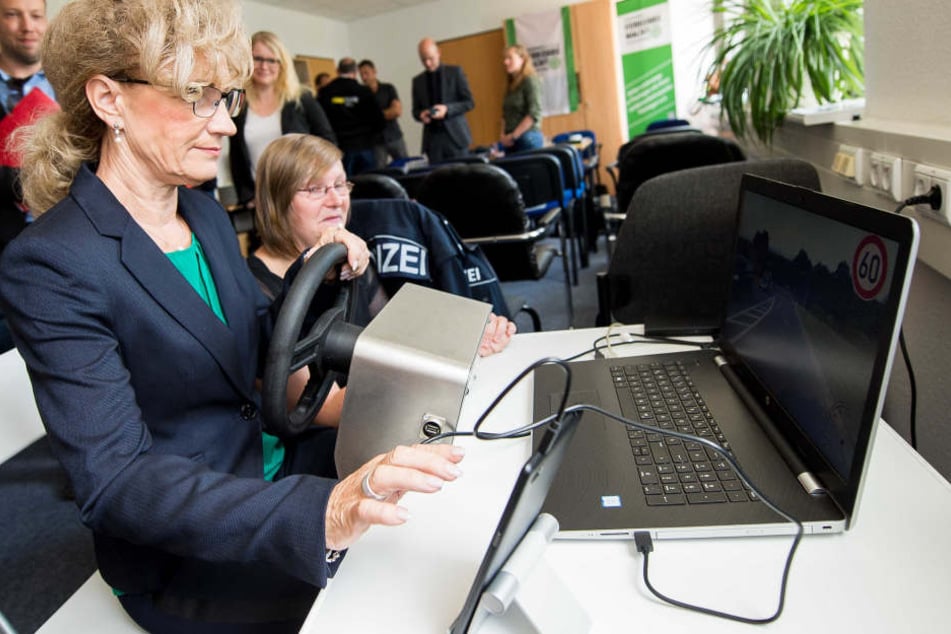 Birgit Keller, Thüringer Ministerin für Infrastruktur und Landwirtschaft versucht sich an einem Fahrsimulator, welcher die verschiedenen Ablenkungen beim Autofahren darstellt. Mandy Passit von der Landesverkehrswacht erklärt ihr das Gerät.