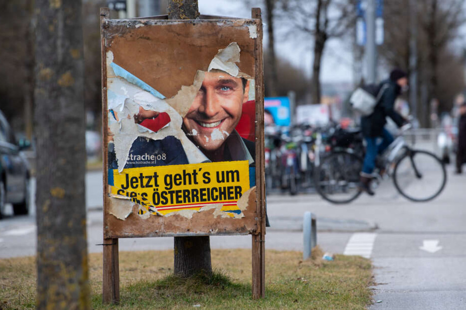 Ein zerstörtes Wahlplakat der CSU steht an einem Straßenrand, darunter kommt ein angerissenen altes Wahlplakat von Heinz-Christian Strache (FPÖ) aus dem Jahr 2008 zum Vorschein.