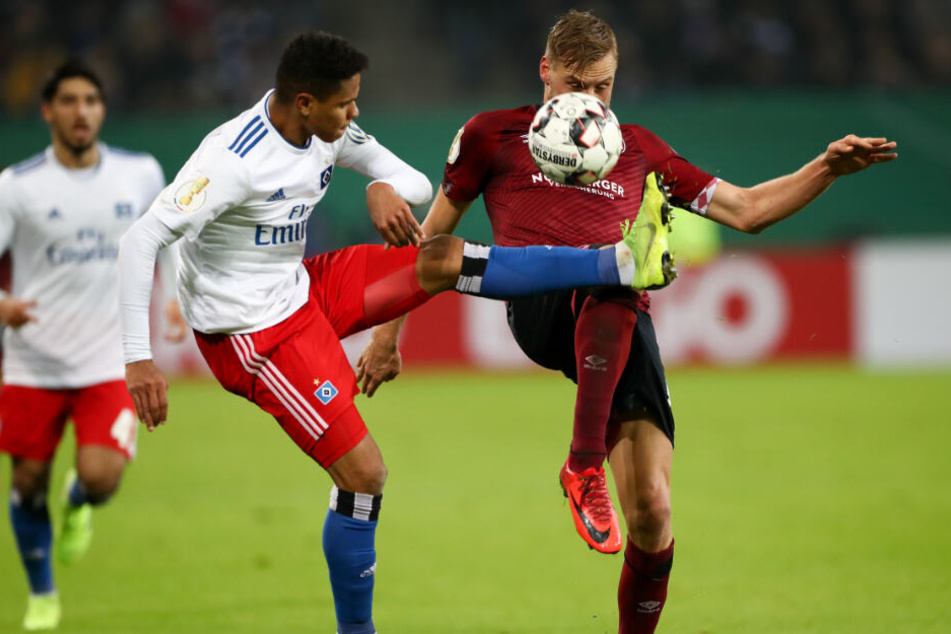 Douglas Santos (links) und Nürnberg-Kapitän Hanno Behrens kämpfen um den Ball.