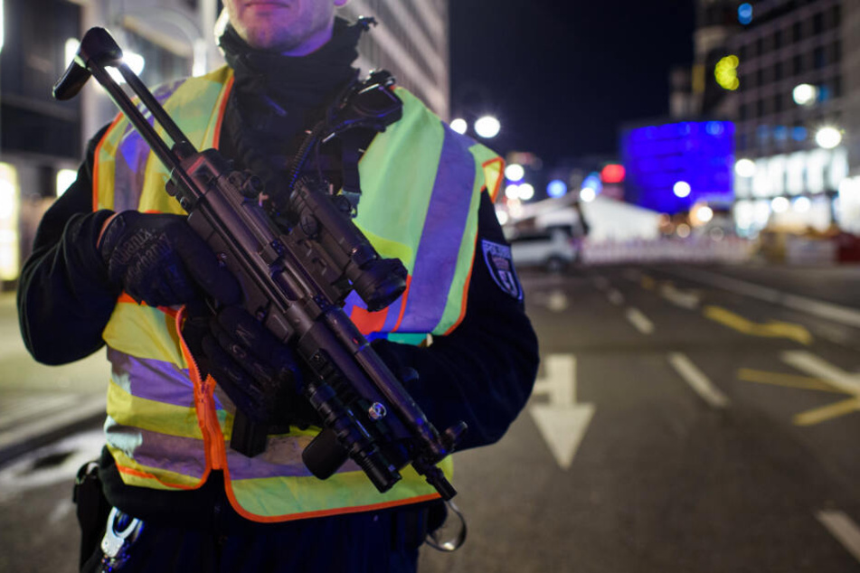 Ein bewaffneter Polizist steht an einer Zufahrt zum Weihnachtsmarkt an der Gedächtniskirche.