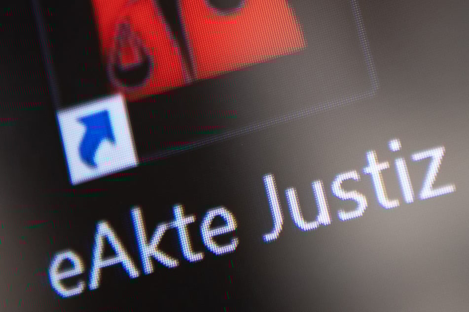 Das Logo der "eAkte Justiz" ist während einer Pressekonferenz nach der Einführung der elektronischen Akte auf einem Monitor zu sehen.