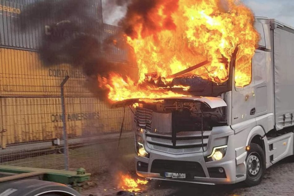 Hohe Flammen schlagen aus der Fahrerkabine des brennenden Lasters im Hamburger Hafen.