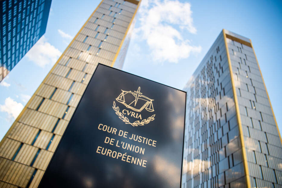 Ein Schild mit der Aufschrift "Cour de Justice de l'union Européene" steht vor den Bürotürmen des Europäischen Gerichtshofs im Europaviertel auf dem Kirchberg in Luxemburg.