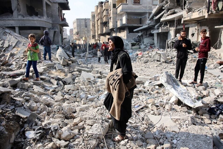 Palestinians walk amid the destruction following an Israeli strike in Jabalia in the northern Gaza Strip on November 10, 2024.