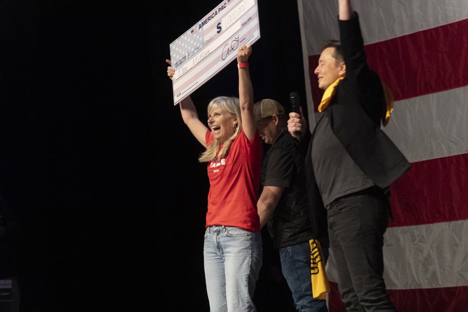 SpaceX and Tesla founder Elon Musk (r.) awarded Kristine Fishell (l.) with a $1 million check during the town hall at the Roxain Theater on October 20, 2024 in Pittsburgh, Pennsylvania.