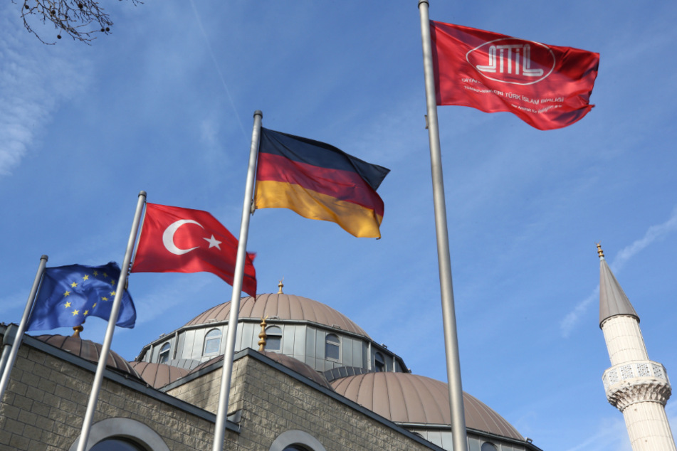 Vor der DITIB-Merkez-Moschee wehen Fahnen von Europa, der Türkei, Deutschland und die Moscheefahne. (Archiv)