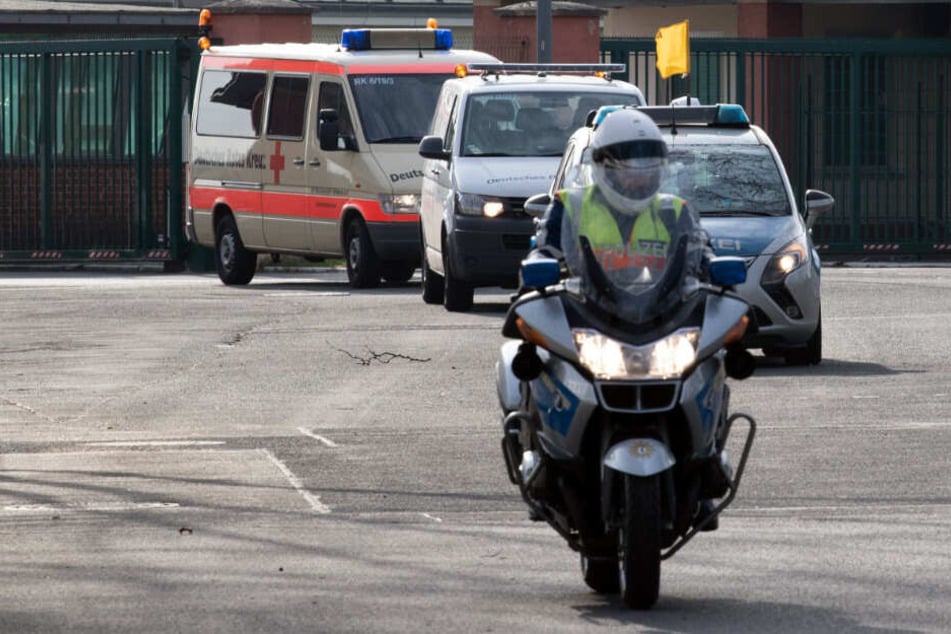 Die Polizei eskortiert einen Krankenwagen mit den China-Rückkehrern.