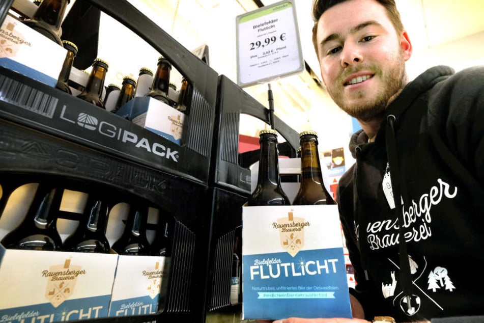 Mike Cacic hält stolz sein eigenes Bier hoch.