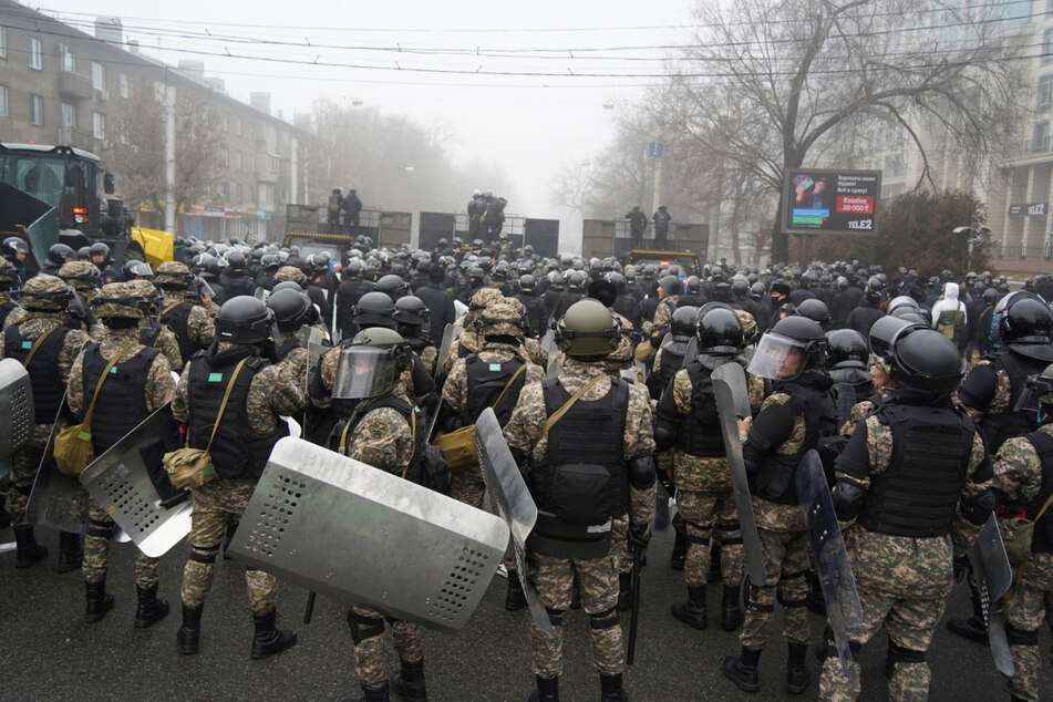 Bereitschaftspolizisten blockieren eine Straße in Almaty, um Demonstranten aufzuhalten.
