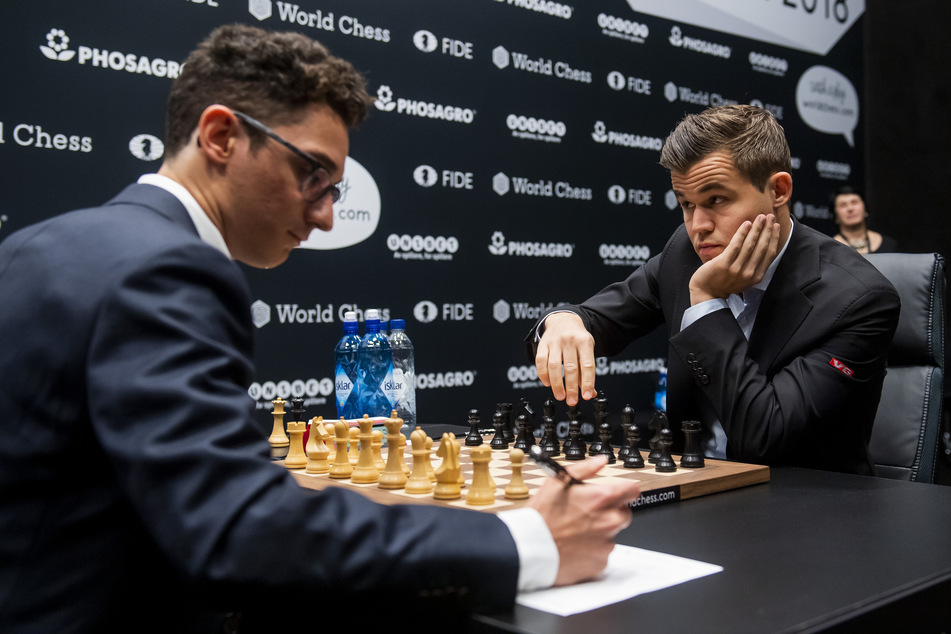 Magnus Carlsen (r.) und Fabiano Caruana sitzen sich am Schachbrett während der Schach-WM 2018 gegenüber.
