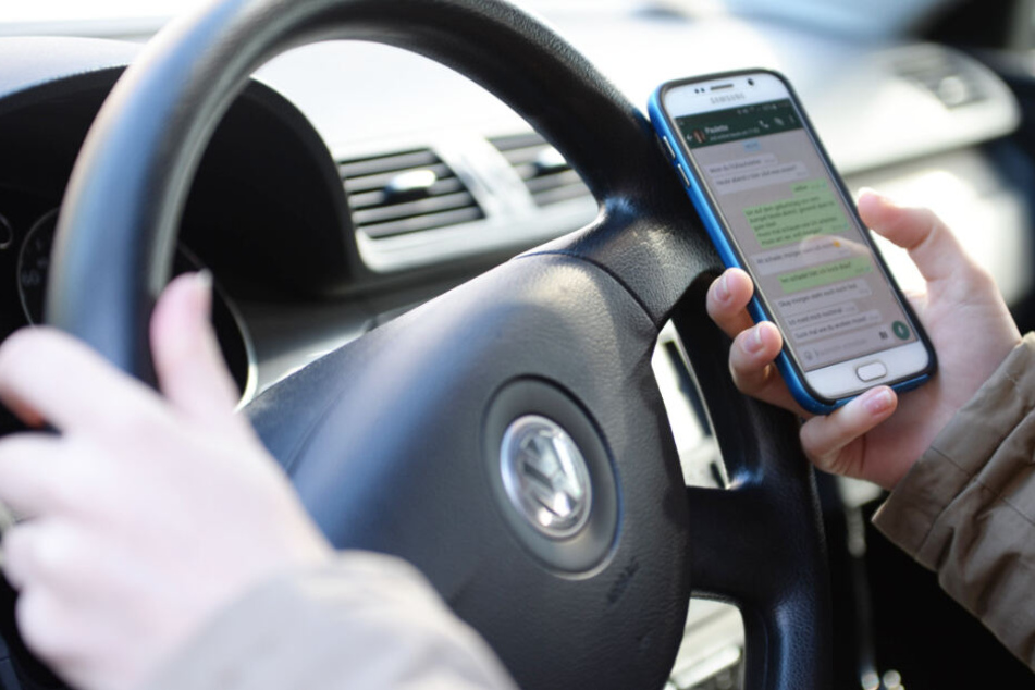 Handy in der Hand? Viele Menschen greifen im Auto zum Smartphone - trotz der Gefahren. (Symbolbild)