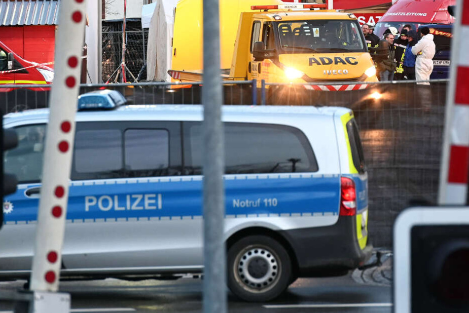 Einsatzkräfte von Polizei und Feuerwehr und ein Abschleppwagen stehen am Dienstag an dem Ort, wo am Montag ein Mann mit seinem Auto in einen Karnevalsumzug gerast war.