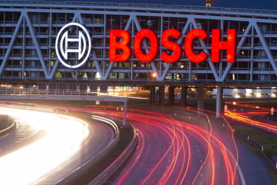 Unter einer Autobahnbrücke mit dem Bosch-Logo fahren Autos.