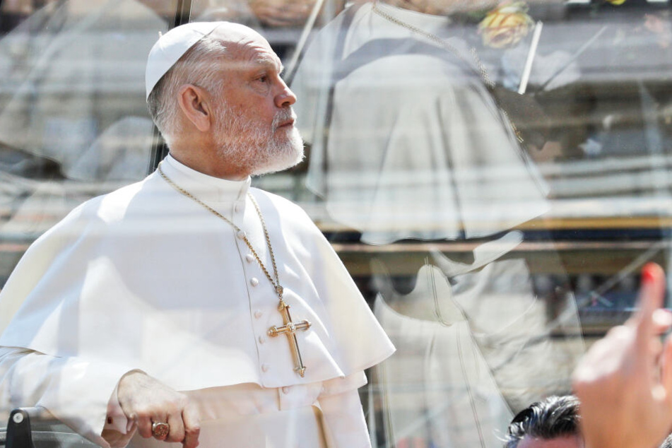 John Malkovich, US-Schauspieler, fährt während der Dreharbeiten der Serie "The New Pope" in einem schwarzen Papamobil.